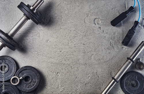 Fitness or bodybuilding concept background. Product photograph of old iron dumbbells on grey, conrete floor in the gym. Photograph taken from above, top view with lots of copy space