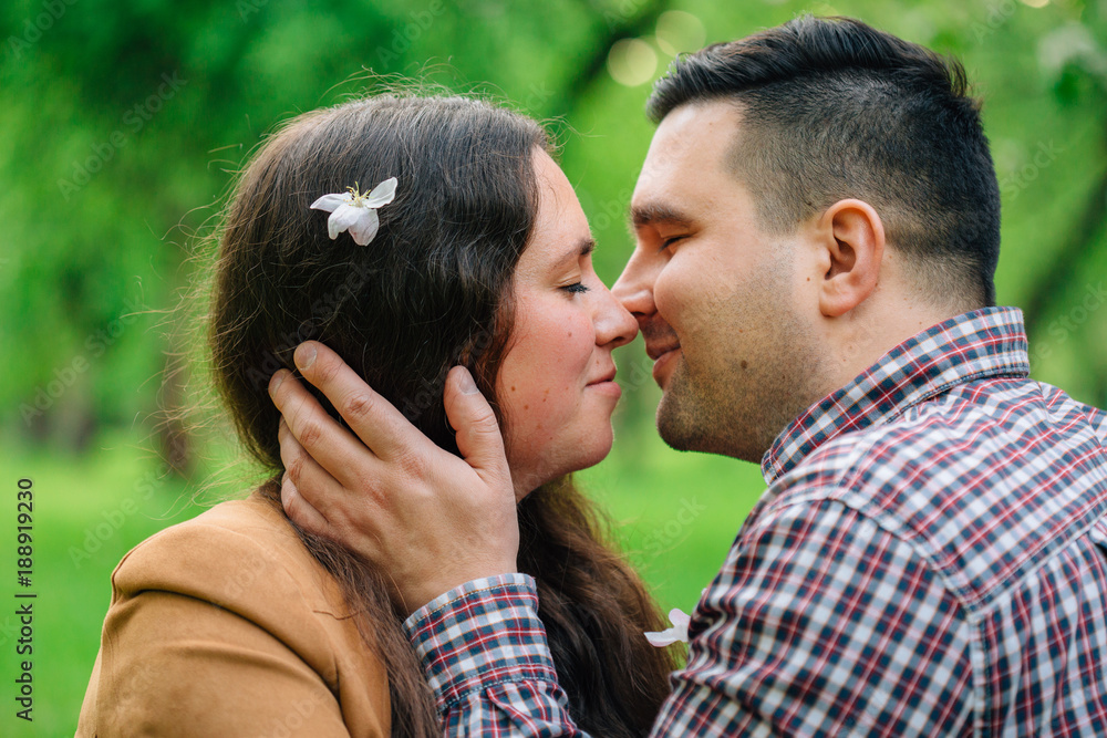 Young stylish couple in love hugging in park. Romantic dating. Pretty girl and man going to kiss. Close up Young stylish couple in love hugging in park. Romantic dating. Pretty girl and man going to kiss. Close up