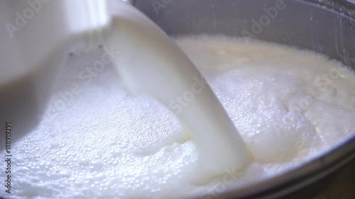 milk products. production of cheese. milk is poured into a cauldron and heated