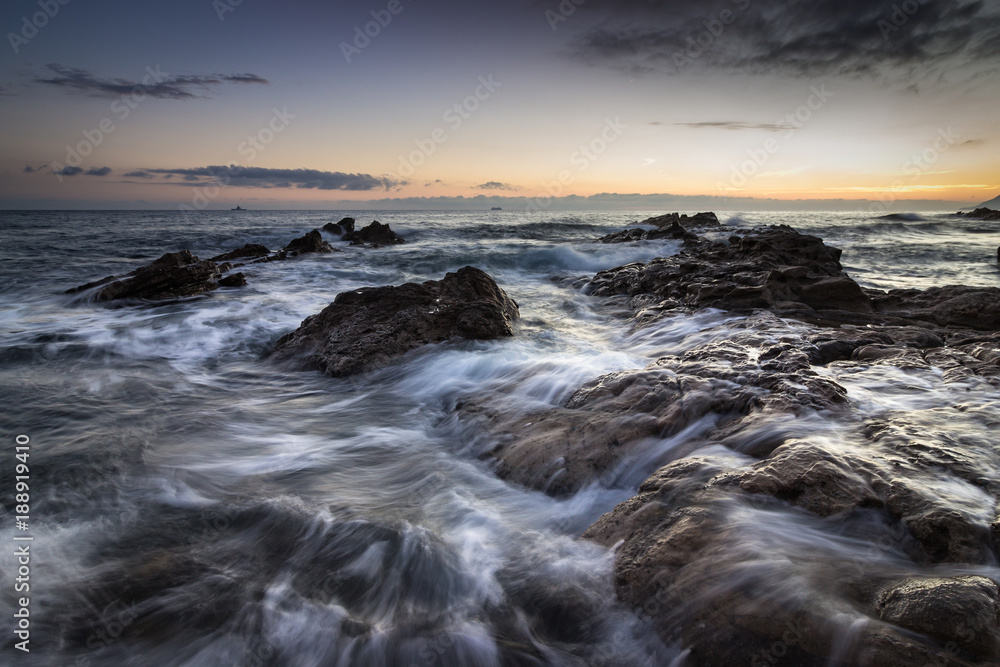 mer agitée sur la côte au coucher de soleil