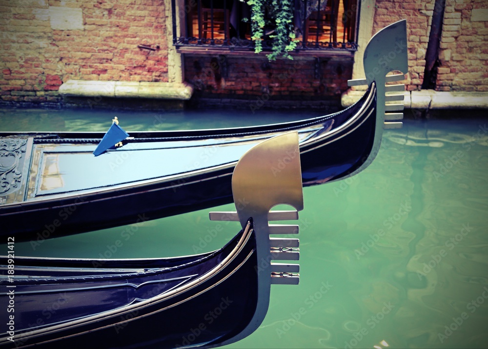 Venice in Italy and the bow of the two gondolas on the waterway