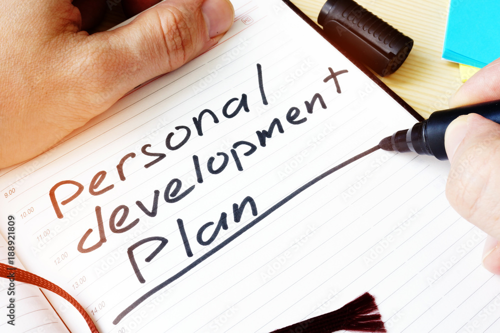 Man writing Personal development plan in a note. Man writing Personal development plan in a note.