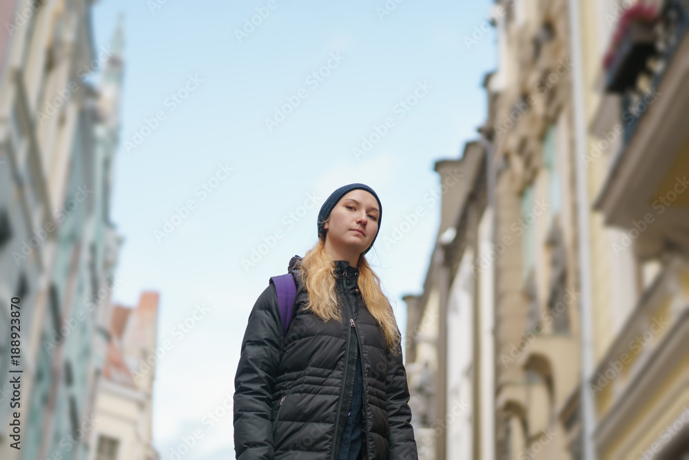 portrait of teen girl walking in old europe city in autumn