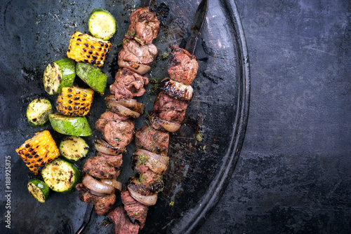 Traditionelle russische Schaschlik Spieße  mit gegrillten Gemüse als Draufsicht auf einem Board mit Textfreiraum rechts  photo