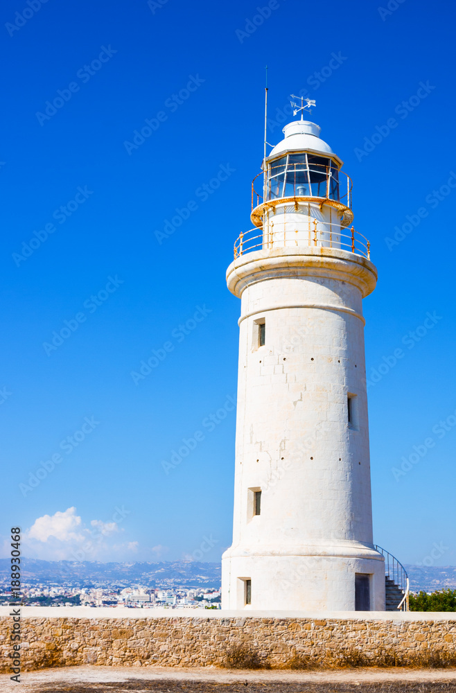 Old white lighthouse near the ancient ruins in Paphos Archaeological Park, Cyprus