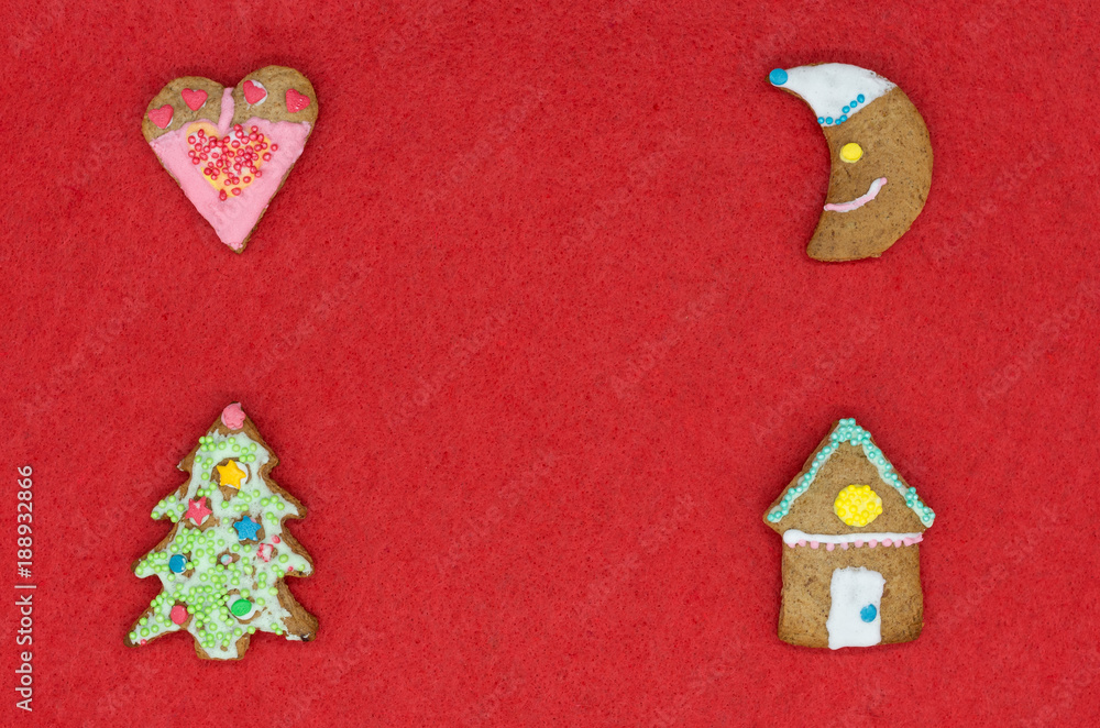 Four homemade Christmas gingerbreads on the red textured background