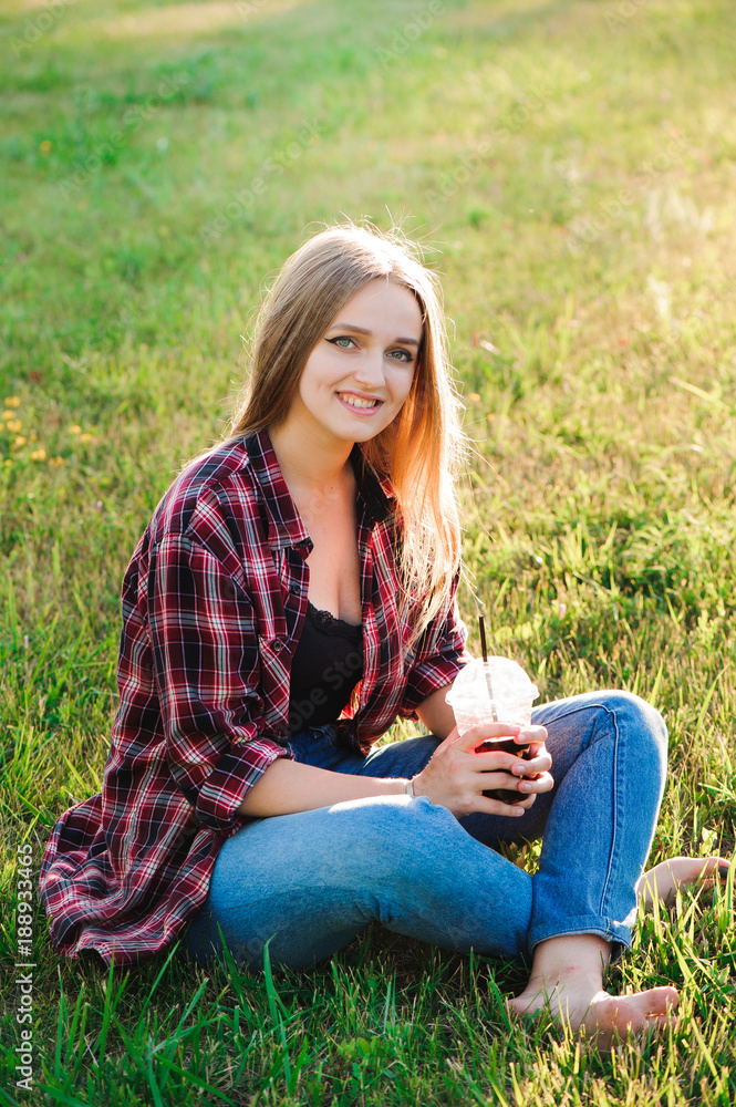Girl with a glass of juice on a green meadow Girl with a glass of juice on a green meadow