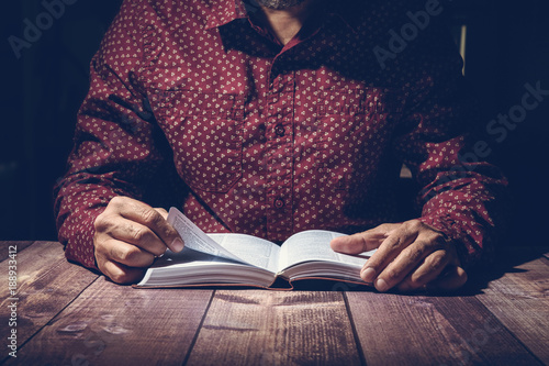 Pastor studying the Bible on a wooden desk photo