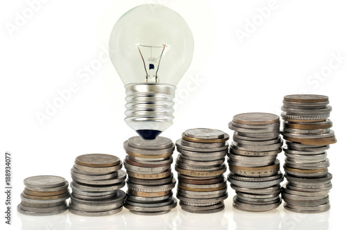 Ampoule électrique posée sur des pièces de monnaie