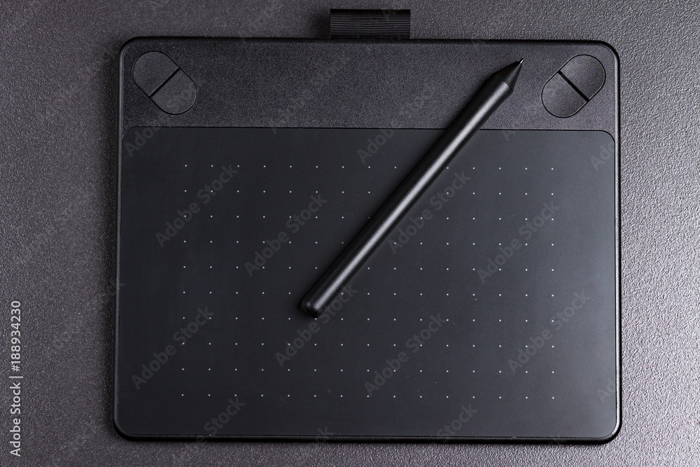graphic tablet with pen on black background top view.