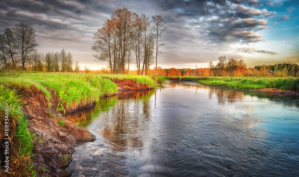 Spring landscape of river in the morning with cloudy sky. Spring wild nature. Scenery view on beautiful river.