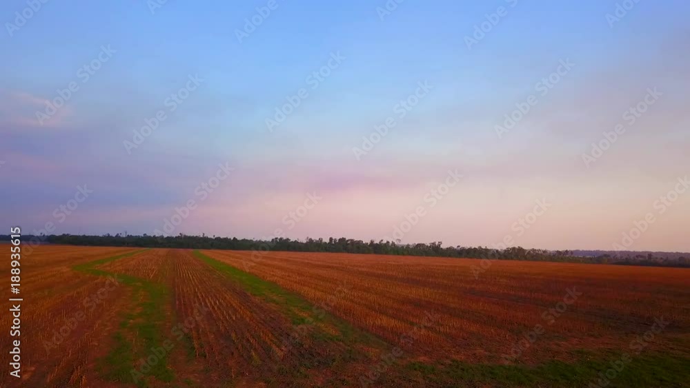 Drone shot flying backwards over a harvested farmers field Drone shot flying backwards over a harvested farmers field