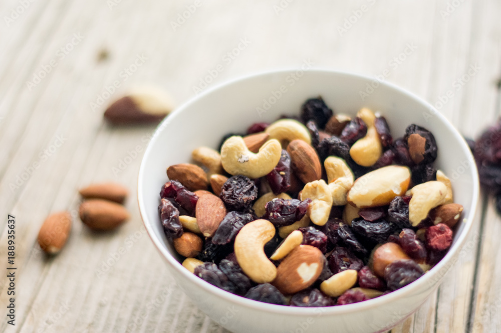 Bowl of mixed nuts and dried fruits on the wooden table Bowl of mixed nuts and dried fruits on the wooden table