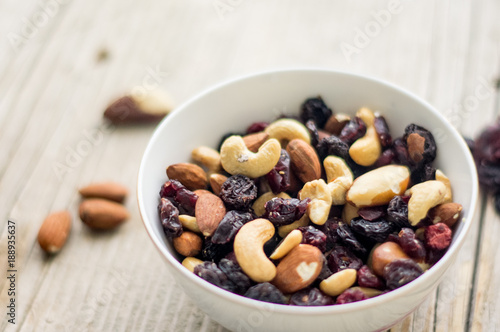 Bowl of mixed nuts and dried fruits on the wooden table