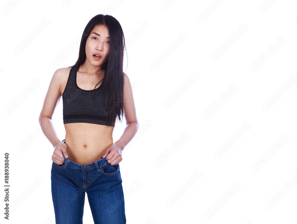 Shocked slim fitness woman in old jeans after losing weight isolated on white background Shocked slim fitness woman in old jeans after losing weight isolated on white background