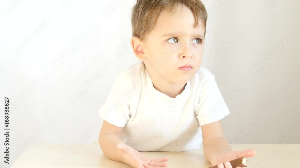 Portrait of a child eating chocolate, on a white background. Portrait of a child eating chocolate, on a white background.