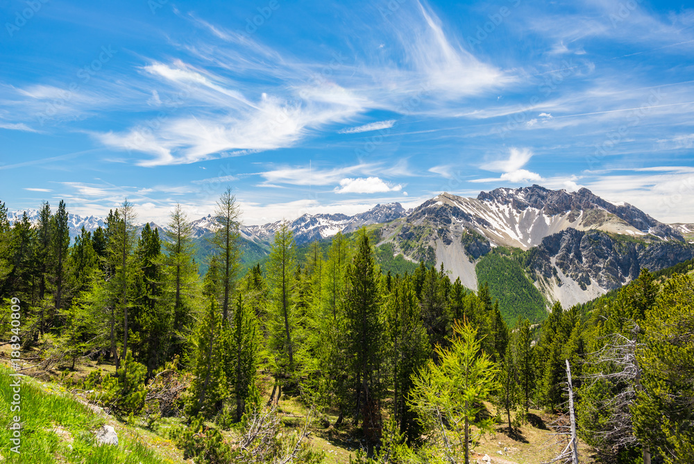 Fototapeta premium High altitude blue lake in idyllic uncontaminated environment once covered by glaciers. Summer adventures and exploration on the Italian French Alps. Expansive view from above, clear blue sky.