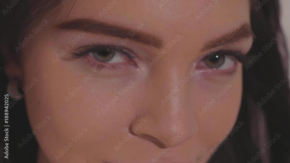 Close-up portrait of pretty young woman playfully looking at camera winking Close-up portrait of pretty young woman playfully looking at camera winking