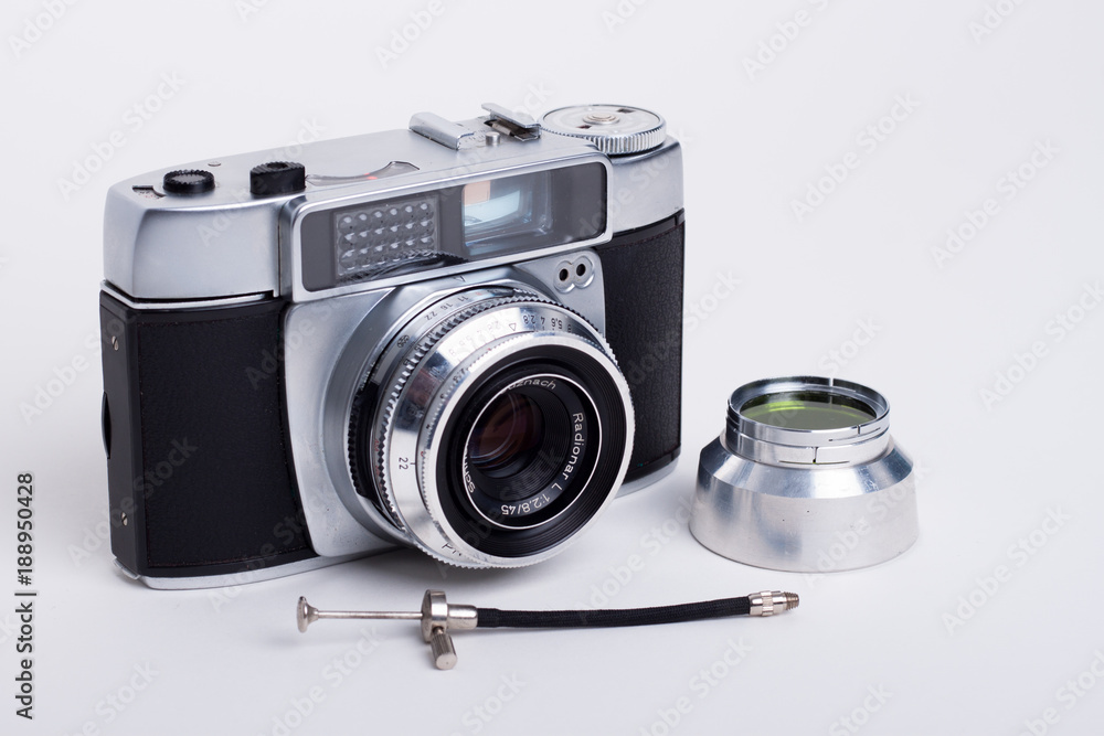 Alte Fotokamera mit Filter und Drahtauslöser auf weißem Untergrund
