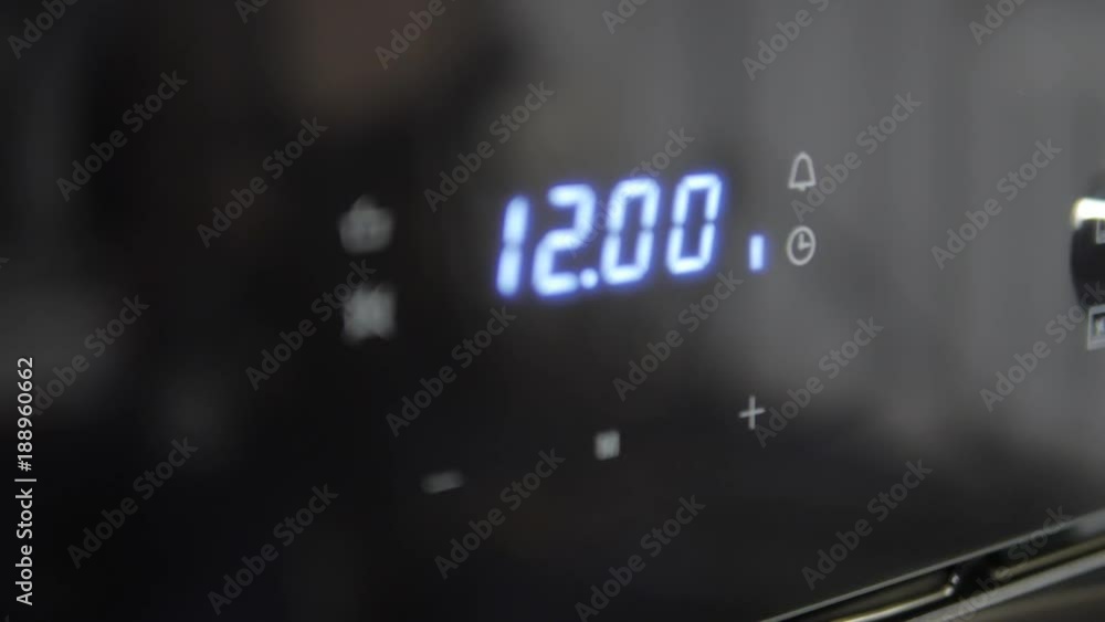 Metallic Toggle Switch of the Cooker Oven. Close-up View. Digital Clock of oven. Front panel of modern black glass oven, red indicators, new shiny buttons. Modern design in details. Metallic Toggle Switch of the Cooker Oven. Close-up View. Digital Clock of oven. Front panel of modern black glass oven, red indicators, new shiny buttons. Modern design in details.