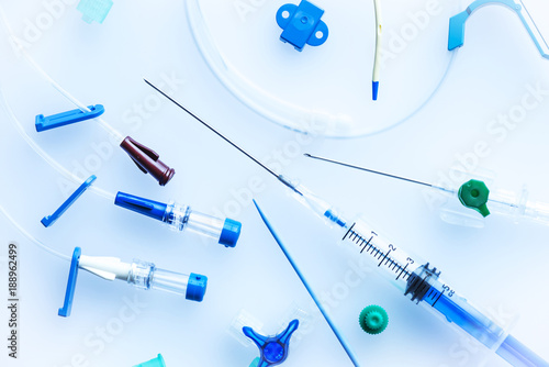 Central venous catheter insertion set with needle,syringe and plastic tubes on blue background