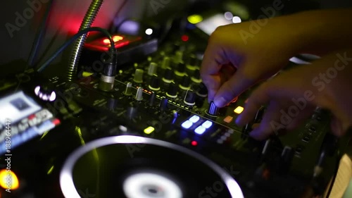 Dj hands playing and mixing music in a nightclub