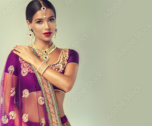 Portrait of beautiful indian girl. Young hindu woman model with kundan jewelry set. Traditional India costume lehenga choli or sari
