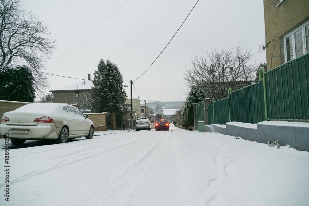 Snow on the streets with cars and buildings. Slovakia