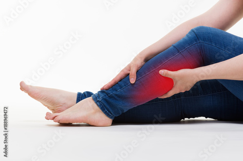 Pain in woman's legs, massage of female feet on white