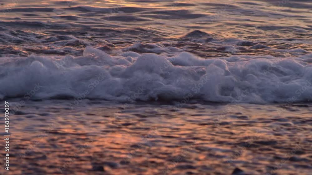 Sea surf waves on the beach at sunrise
