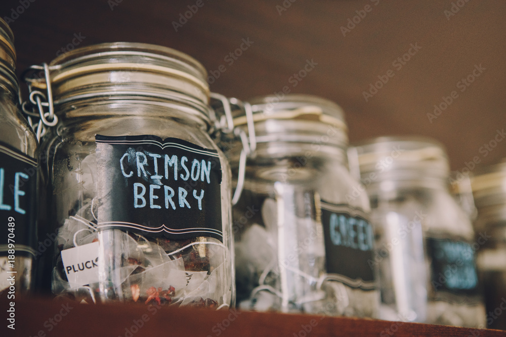 Interior of coffee shop. Glass jars with tea bags on shelves. Toned with retro vintage film effect filters. Interior of coffee shop. Glass jars with tea bags on shelves. Toned with retro vintage film effect filters.