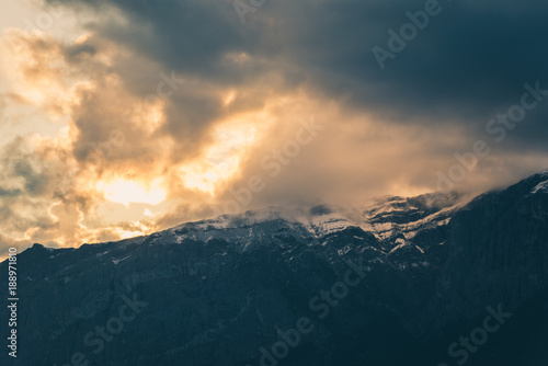 Moody clouds at sunset above rocky mountains