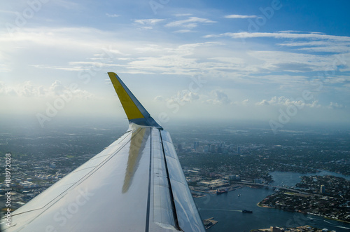View of an airplane wing flying over the city