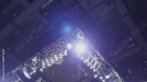 Strobe lights emitting different color beams hanging under the ceiling. Spotlight filler lights mounted on the ceiling photo