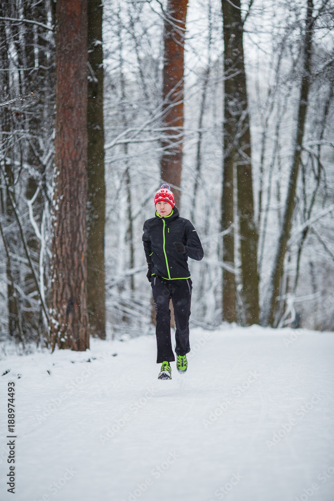 Photo of running athlete among trees in winter forest