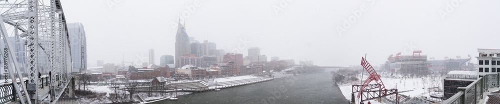 Nashville Skyline and Pedestrian Bridge during Snow Storm with Stadium and River