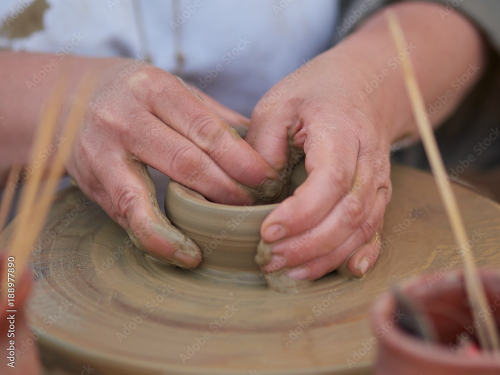 female Potter creating a bowl on a Potters wheel