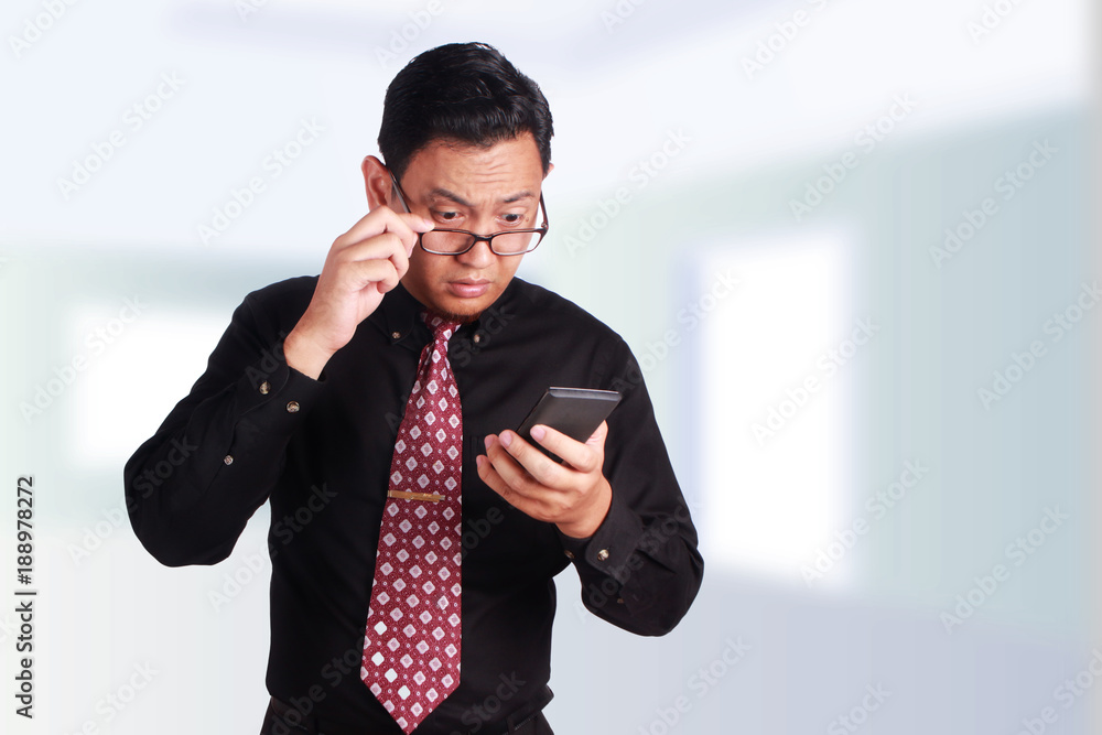 Young Businessman Reading Text on Smartphone Young Businessman Reading Text on Smartphone