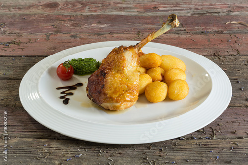 Roasted chicken legs and stuffing on a plate. On a wooden background. rustic food