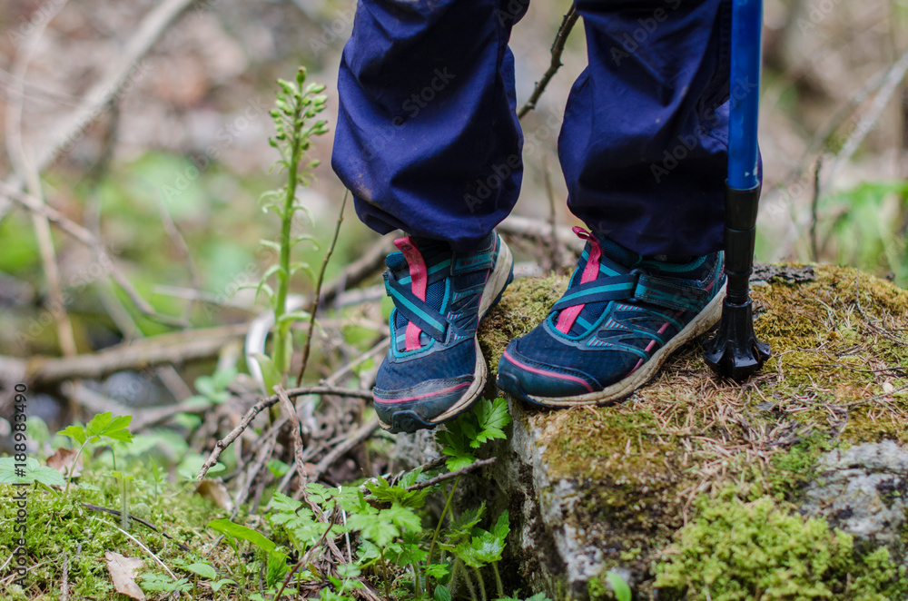 child's feet stand on a rocky mountain trail