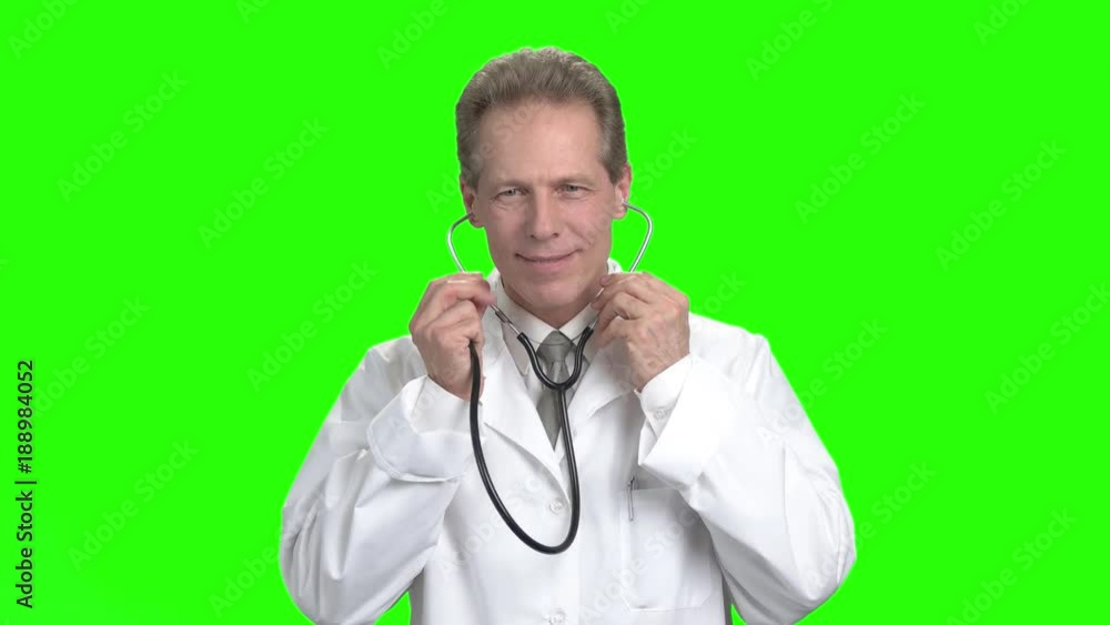 Mature doctor using stethoscope. Portrait of middle aged doctor put on stethoscope and listening heartbeat. Mature doctor using stethoscope. Portrait of middle aged doctor put on stethoscope and listening heartbeat.