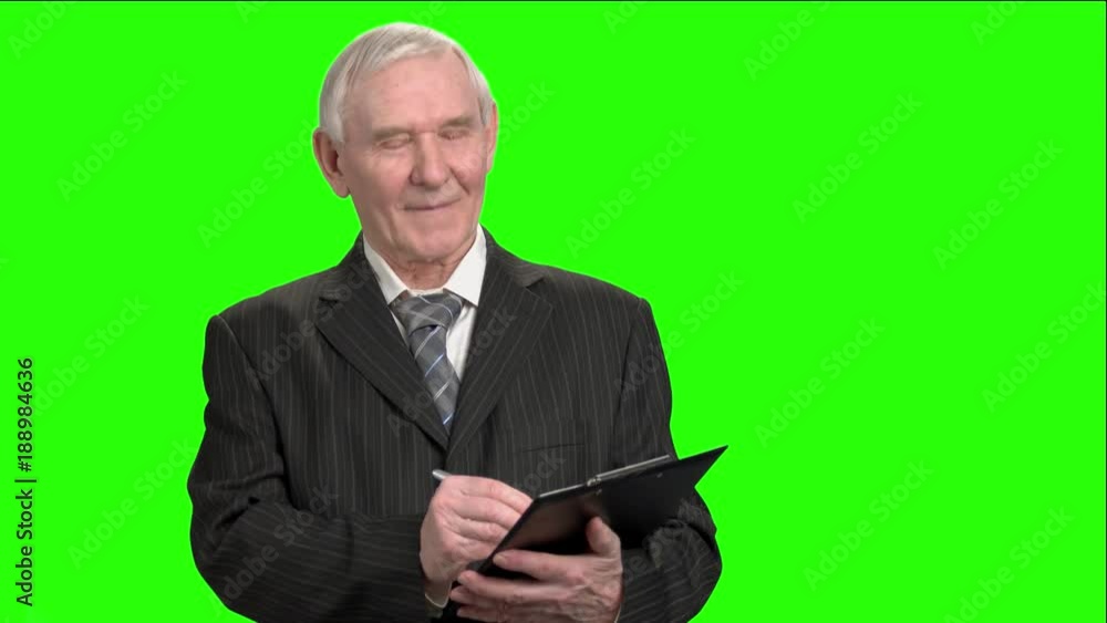 Smiling tax inspector writing down on clipboard. Cheerful smiling old tax inspector writing down info on clipboard. Smiling tax inspector writing down on clipboard. Cheerful smiling old tax inspector writing down info on clipboard.