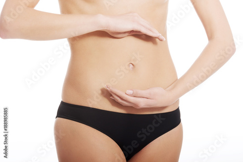 Caucasian woman is holding hand on her belly.