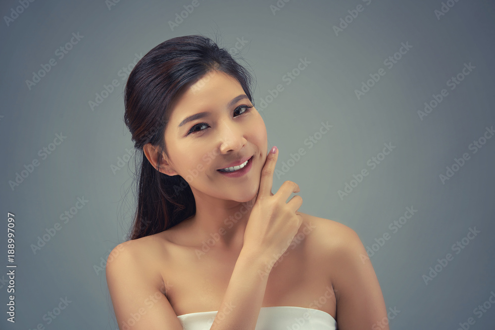 Happy beautiful asian girl with the fresh skin in grey colour background. Expressive facial expressions. Cosmetology and Spa concept. Happy beautiful asian girl with the fresh skin in grey colour background. Expressive facial expressions. Cosmetology and Spa concept.