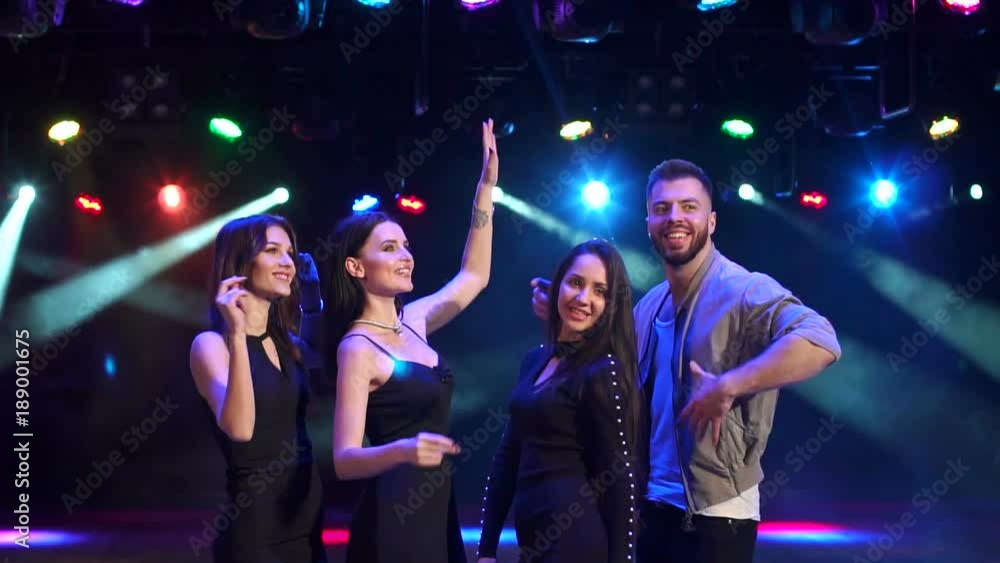 Four friends dancing in the night club in the dark in the light colored spotlights, slow motion. Four friends dancing in the night club in the dark in the light colored spotlights, slow motion.
