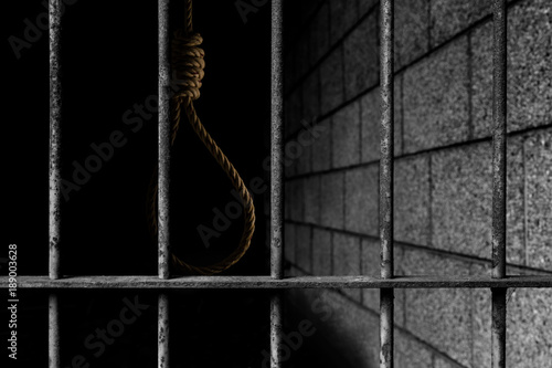 Old prison bars cell lock background dark black and light with rope noose inside, concept of justice photo
