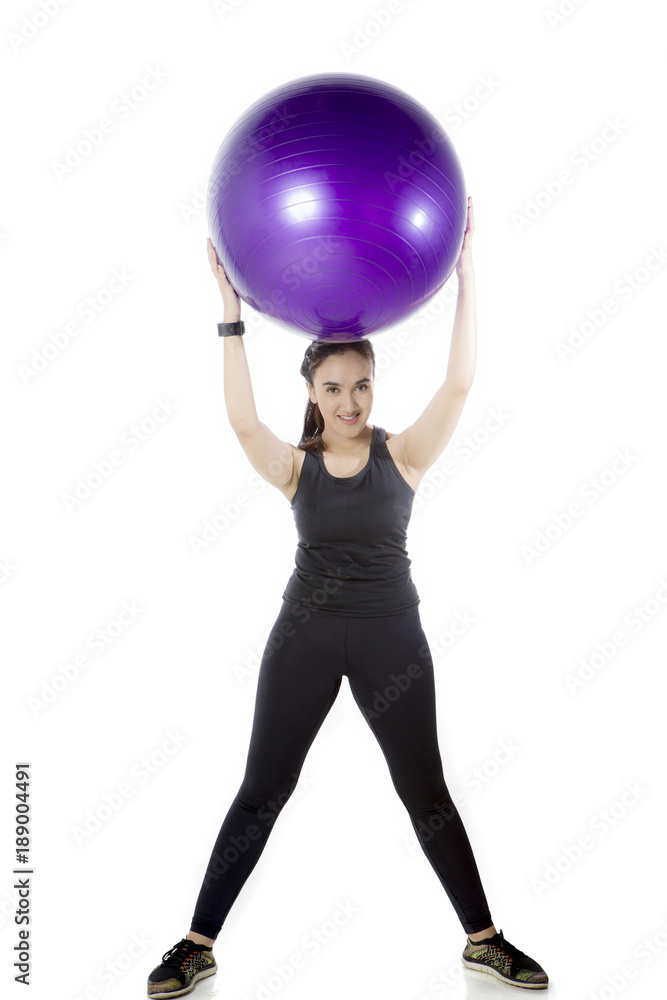 Arabian woman lifting a fitness ball on studio Arabian woman lifting a fitness ball on studio