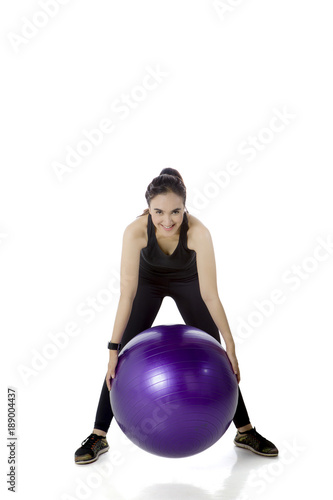Arabian woman exercising with fitness ball on studio
