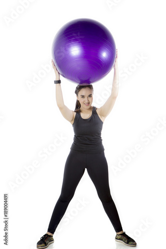 Arabian woman lifting a fitness ball on studio