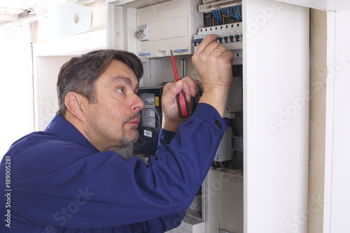 Elektroinstallateur schraubt an Sicherungskasten